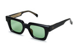 Three-quarter view of chunky black acetate frame with green tinted lenses and gold detail temples
